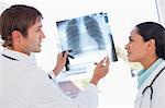 Médecins sérieuses parle d'une radiographie pulmonaire en se tenant debout devant une fenêtre
