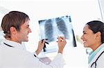 Two doctors working on a chest x-ray while smiling and looking at each other