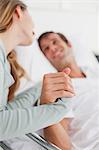 Hands being held by a young smiling couple in a hospital room