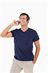 Happy man using his mobile phone while laughing and placing his hand in his pocket