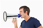 Furious man shouting through a megaphone against a white background