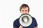 Furious man using a megaphone to talk against a white background