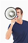 Furious man using a megaphone while shouting against a white background