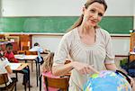 Elementary teacher standing next to globe