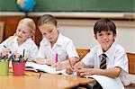 Young pupils painting at desk