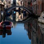 Moored boats and bridge on canal in Cannaregio district, Venice.