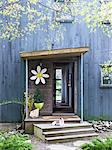 Entrance to timber weekend retreat with oversized ceramic daisy, by Joseph Holtzman, the former editor of Nest magazine. Designed by Designed by Todd Oldham