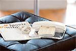 Telephone And Book On Leather Chair