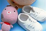 Chaussures de bébé, jouets et un chapeau sur chaise