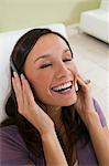 Woman sitting on sofa Listening to Music on Headphones, elevated view, close up