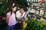 Grandmother with granddaughter looking at plants in nursery