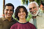 Boy (13-15) with Father and Grandfather outdoors, front view portrait.