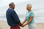 Senior couple holding hands on beach