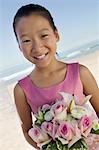 Young Bridesmaid with flowers on beach, (portrait)