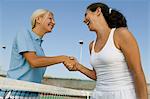 Zwei weibliche Tennis-Spieler Schütteln von Hand über Tennis Gericht netto, niedrigen Winkel anzeigen