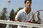 Male doubles tennis players waiting for serve, front view, focus on foreground