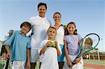 Family on Tennis Court by net, portrait, front view