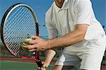 Hommes Tennis Player se préparent à servir, moyenne section, faible angle vue