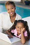 Mother and Daughter Using Laptop on patio, portrait, high angle view