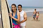 Famille avec planche de surf sur la plage