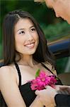 Well-dressed teenage girl receiving corsage from date