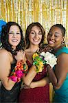 Well-dressed teenage girls showing corsages at school dance, portrait