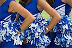 Cheerleaders holding pom-poms, (mid section), (close-up)