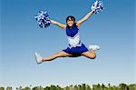 Smiling Cheerleader jumping in mid-air, (portrait)