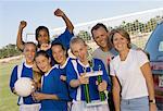 Parents avec soccer filles de l'équipe (13-17) holding trophy, portrait