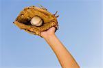 Baseball player catching ball in baseball glove, close-up of hand in glove