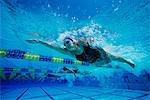 Female swimmers racing underwater in pool