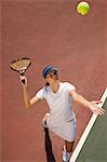 Woman on tennis court Serving Tennis Ball, elevated view