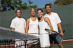 Mixed Doubles Tennis Players standing at Net, arms around