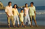 Famille avec la fille (7-9), se promener sur la plage