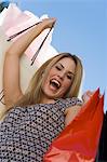 Young woman with shopping bags, outdoors, (portrait)