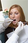 Junge Frau, die Zähne untersucht Zahnärzte