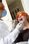 Dentist examining womans teeth in surgery