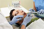 Dentists examining male patient in surgery, (close-up)