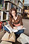 Female college student making notes in library