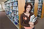 Female student holding books in library