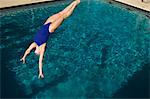 Young woman diving into swimming pool