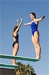 Two women standing on diving boards