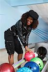 Young woman selecting bowling ball, portrait