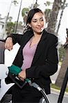 Businesswoman filling car at gas station