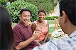 Two couples drinking wine in garden