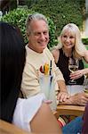 Three friends drinking wine in garden