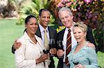 Two couples holding wine outdoors, portrait