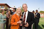 Couple holding wine at outdoor party, portrait