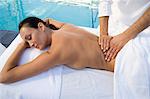 Woman having massage by swimming pool