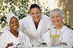 Portrait of three women in bathrobes at health spa